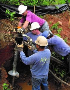 four people doing helical pier installation at Atlanta home