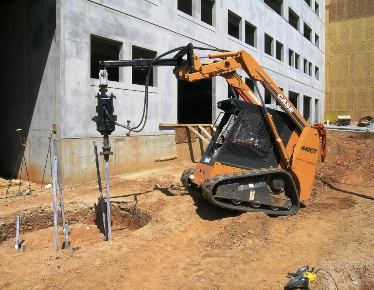 bobcat pulling pillars into ground