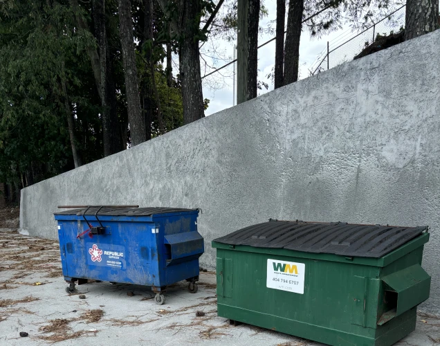 Waste Management and Republic trash bins in front of a new retaining wall by Atlas Piers